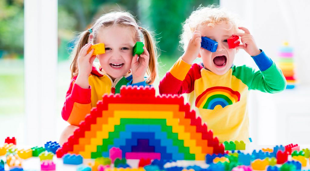 Two Kids building a rainbow with building blocks